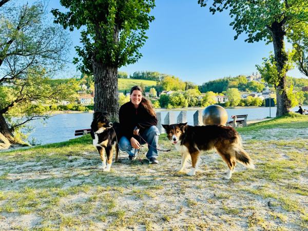 Evi mit zwei Australian Shepherds an einem See in Oberbayern